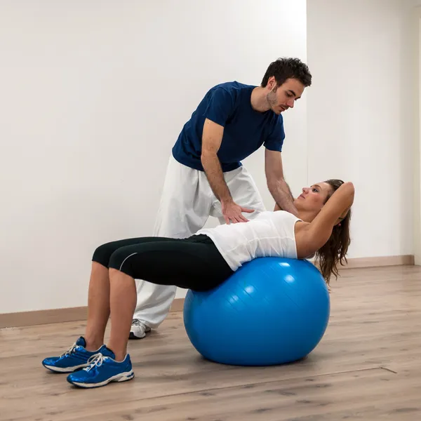 Woman exercising with her personal trainer at the gym