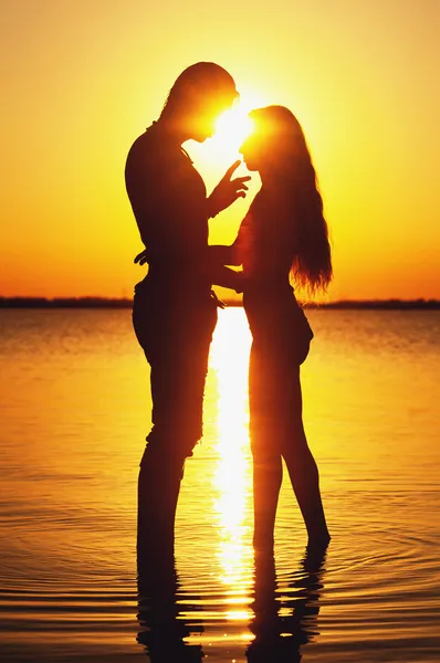 Couple silhouette at the beach. Sunset light