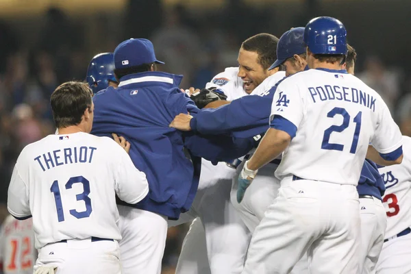 James Loney gets rushed by teammates after batting in the winning run of the game