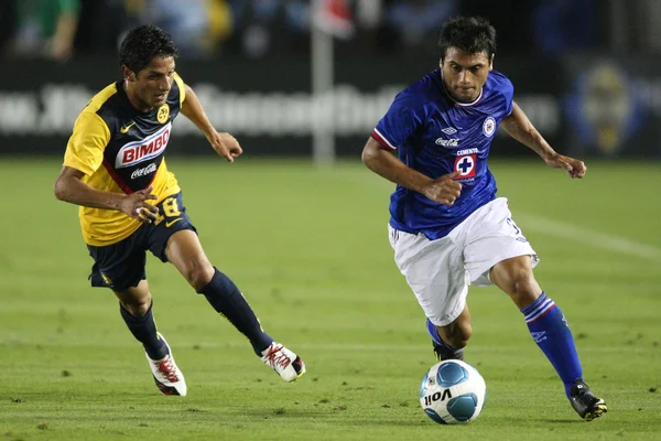 Maximiliano Biancucchi dribbles away from Club America Angel Reyna during the game