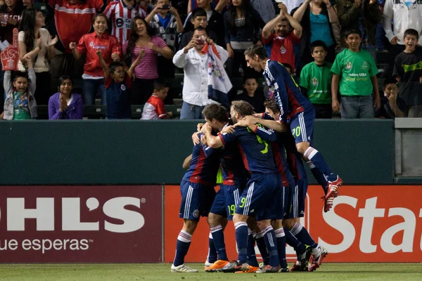 Zarek Valentin jumps on top of the pack of Chivas players in celebration of a 1st half goal during the game