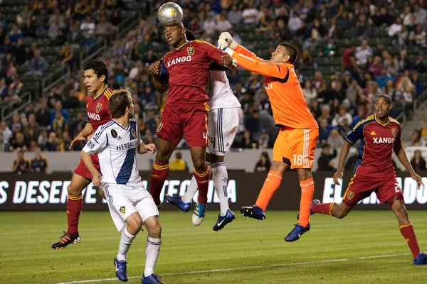 Jamison Olave gets a head on a corner kick while Nick Rimando tries to punch it away during the game