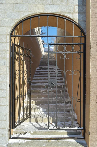 Metal grating with an open gate on the leading up stairs