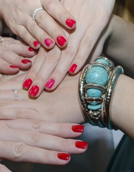 Red nails and turquoise jewelry on female hands