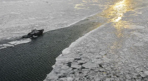 Small icebreaker breaking the ice in the river