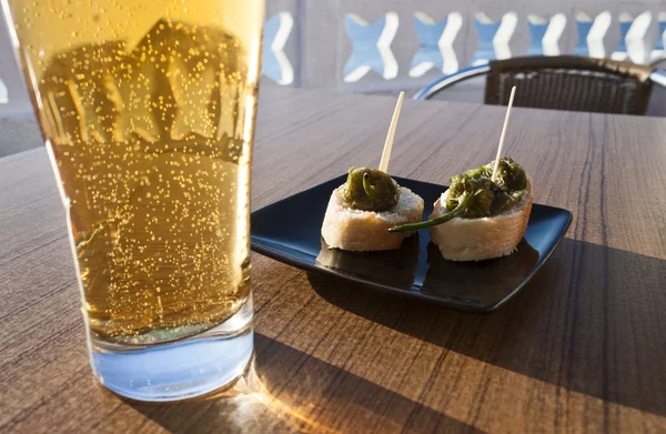 Small green peppers bites with beer.