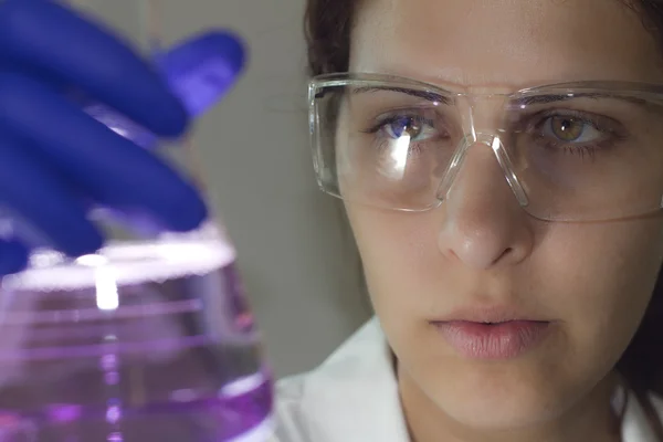 Scientist using a light scope examination to analyze a chemical