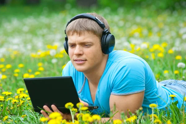 Young man using a laptop and listening music