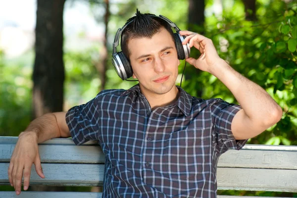 Portrait of a young man listening to music outdoors