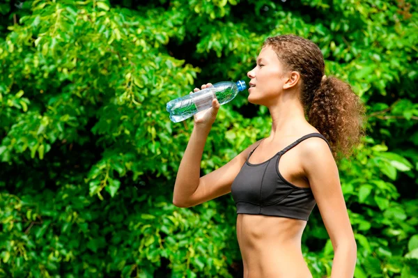 Woman drinking water after fitness