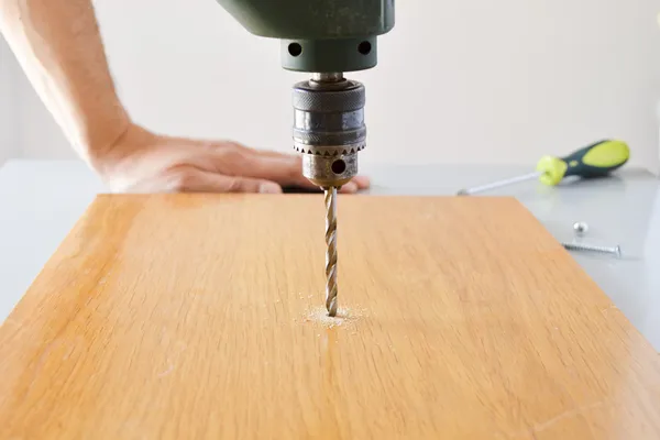 Electric drill drilling a hole in timber