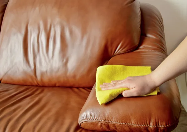 Hand wiping couch brown