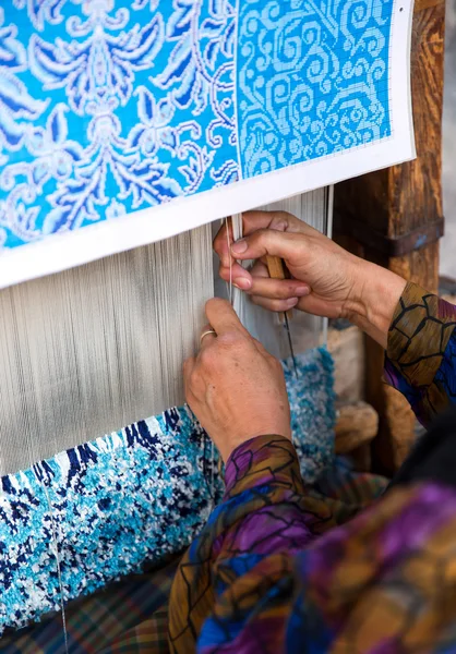 Woman hands weaving carpet