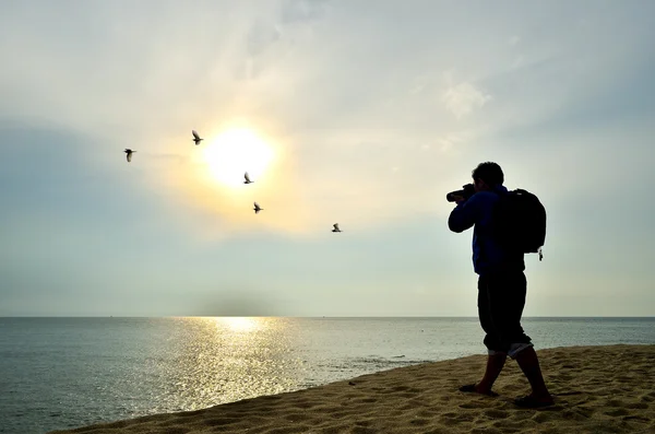 Photographer silhouette shooting sun rising