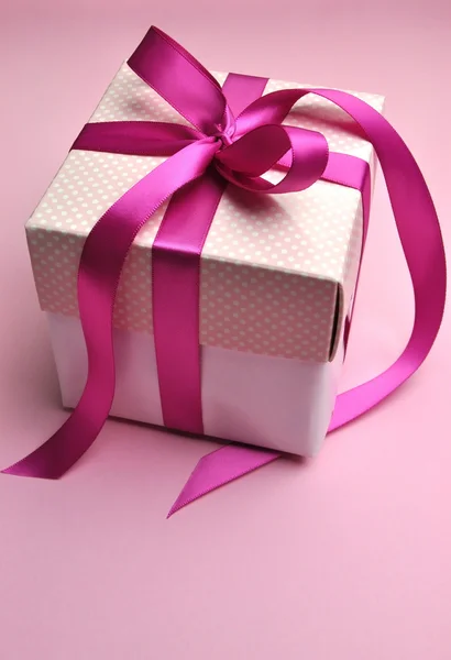 Beautiful pink present gift with polka dots and bright candy fuchsia pink bow