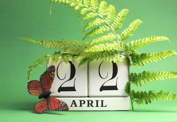 Earth Day, save the date white block calendar, April 22, with butterfly and ferns against a green background.