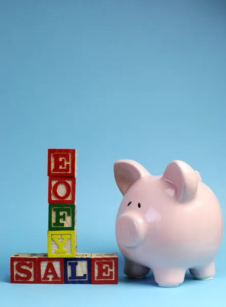End of Financial Year sale message on building blocks with piggy bank - vertical with copy space for your text here.