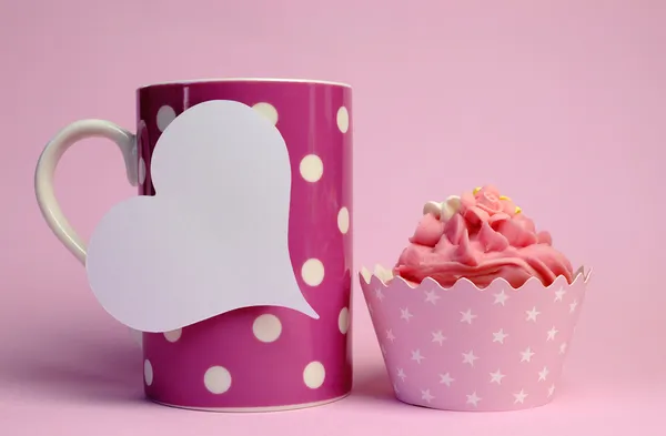 Pink polka dot coffee mug with pink cupcake and blank white heart shape gift tag for your text here, for female birthday, mothers day, or special occasion event.