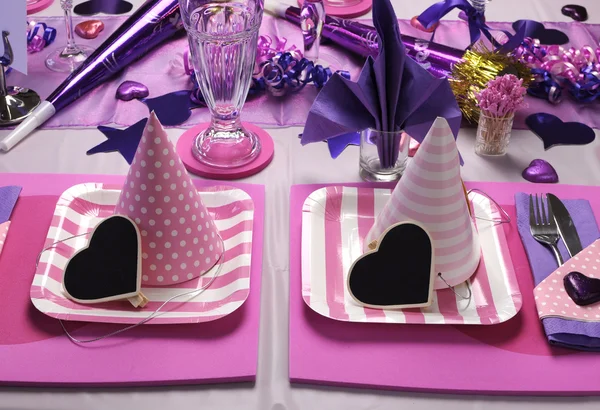 Pink and purple theme party table setting decorations.