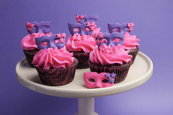 Pink and purple masquerade masks decorated party cupcakes with pink frosting for teenage, birthday, New Years Eve, or wedding bridal shower party