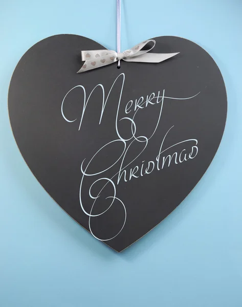 Merry Christmas greeting message on heart shape blackboard