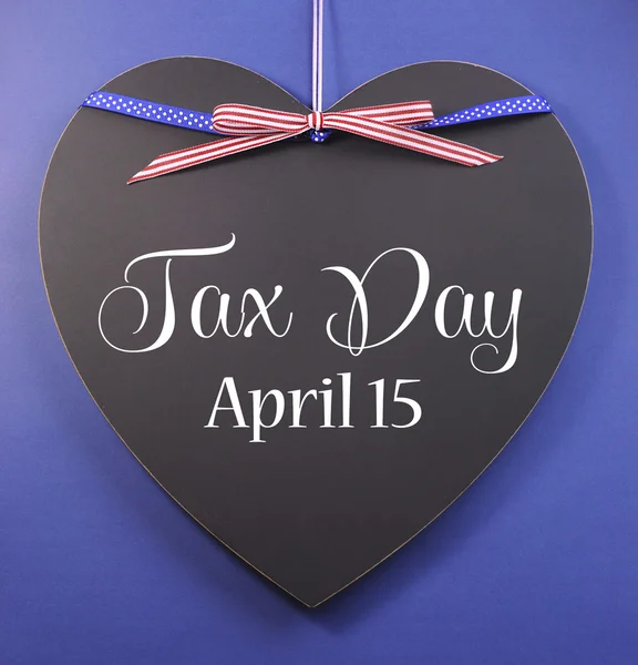 Tax Day, April 15, reminder greeting message with USA ribbon on a heart shaped blackboard