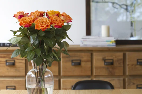 Orange roses on dining table interior scene