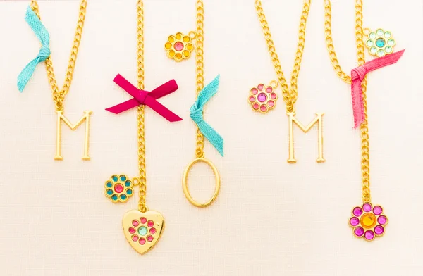 Mom spelled out in gold jewelry