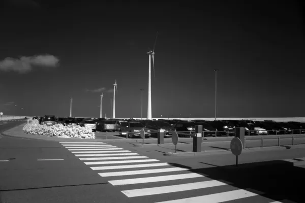 Eemshaven, Netherlands: July 29, 2014 - infrared photo of parking space with windmill