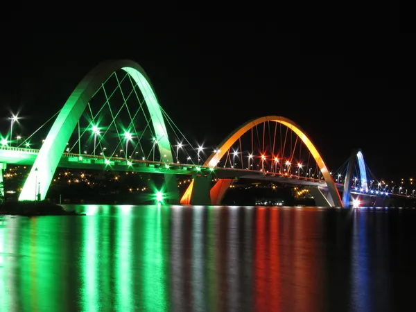 Kubitschek Bridge reflected in the lake at night with colored lighting