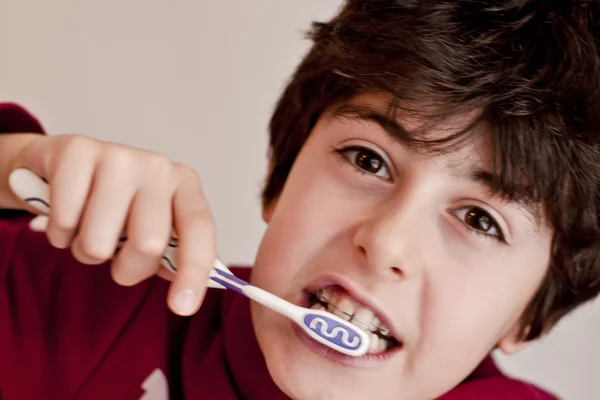 Happy teen with braces and brush his teeth