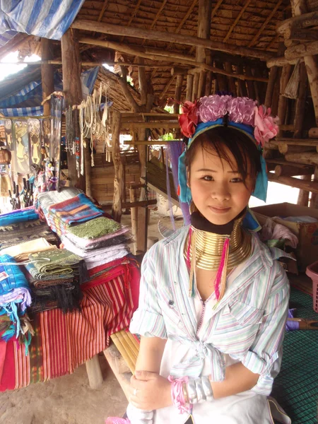 CHIANG MAI, THAILAND - JUNE 2012: Unidentified girl from long neck Karen tribe sells souvenirs on June 2012 in Chiang Mai. Many Karen tribes fled to Thailand due to conflict with the regime in Burma.
