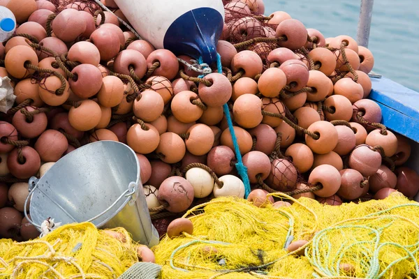 Fishing tackle: net, bucket, buoy on the boat desk