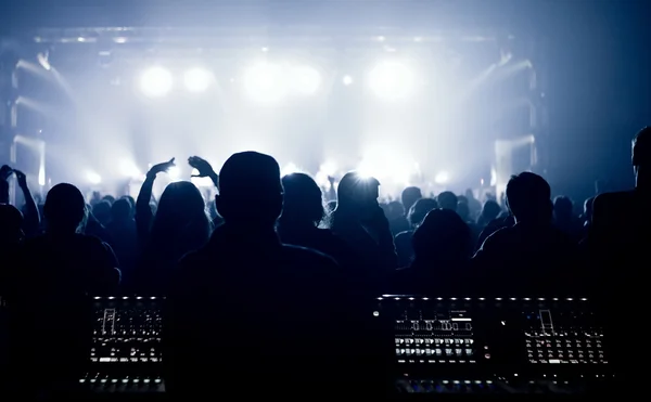 Crowd, cheering and watching a band on stage