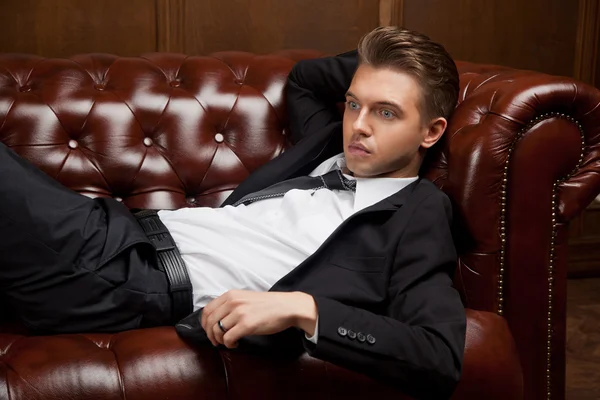 Stylish man in a suit lying