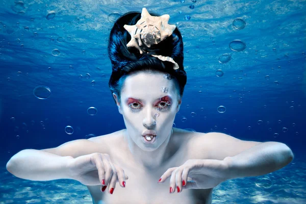 Mermaid under water with a pearl