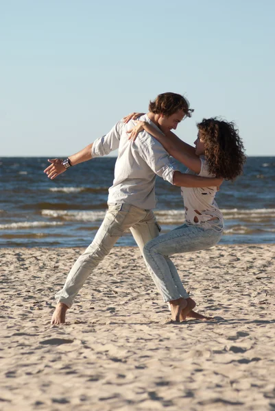 Young couple dancing tango on the beach