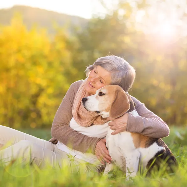 Active senior woman hugs dog