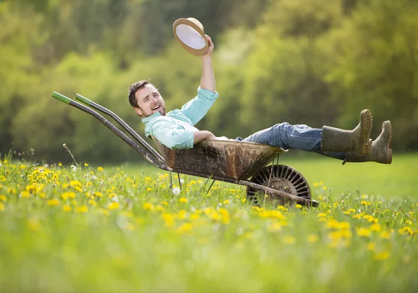 Farmer is relaxing in wheelbarrow
