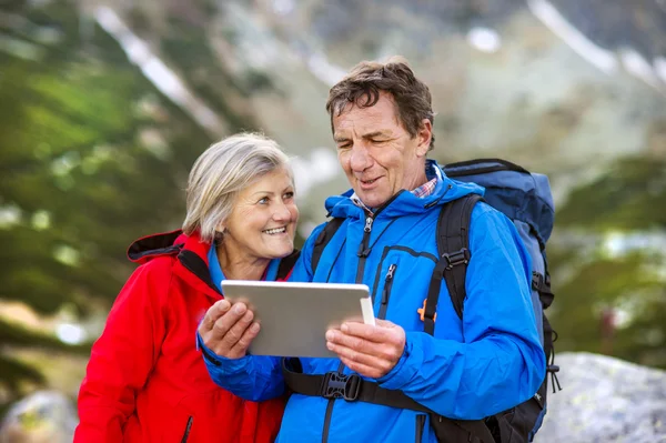 Senior couple using map on tablet