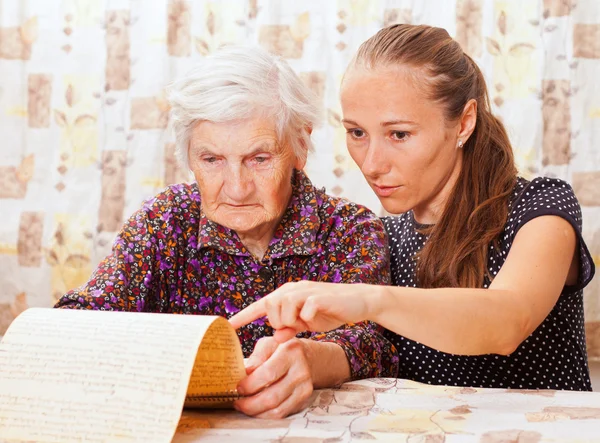 Young doctor holds the old woman\'s hand