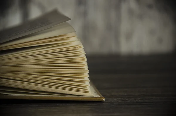 Vintage book, open, on old wooden table, with clipping path