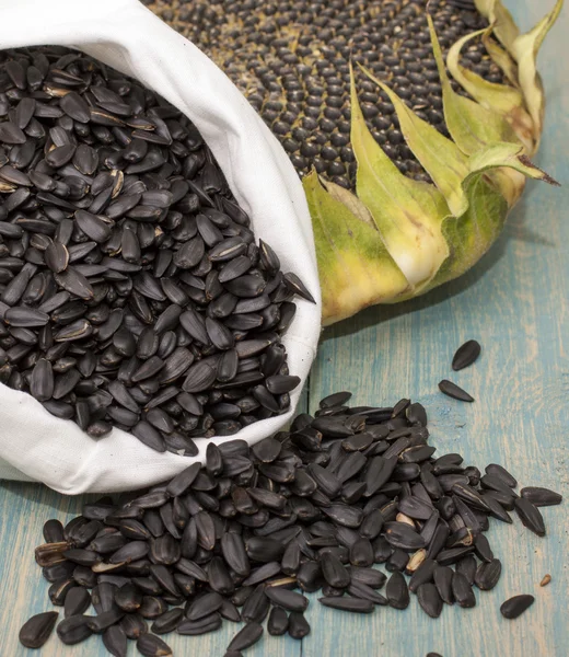 Sunflower seeds in a bag and head sunflower.