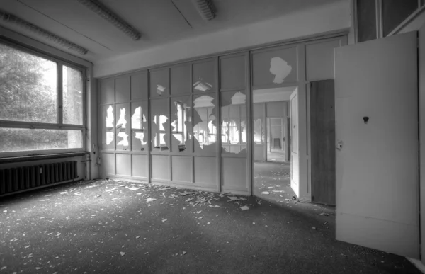 Abandoned empty office rooms with broken windows