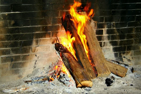 Burning logs in a brick fireplace