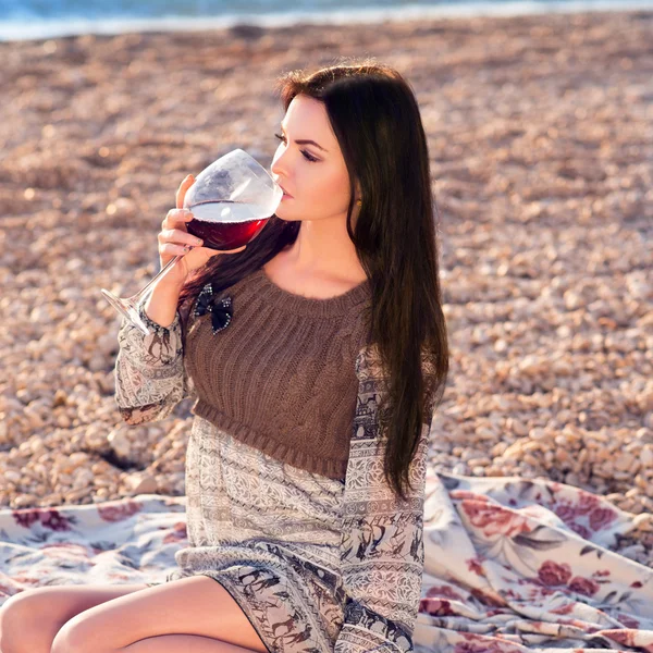 Young woman holding glass of red italian wine. sunset