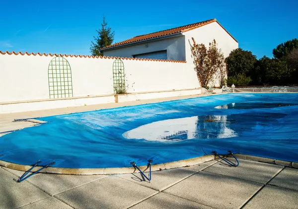 Pool protected by a pool cover during winter months