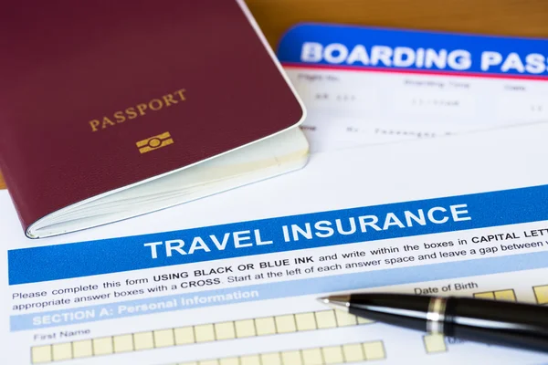 Travel insurance application form with pen and passport