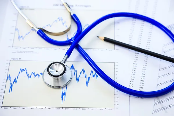 Stethoscope and finance document for financial health check conc