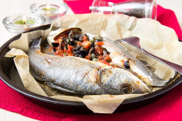 Baked whole white fish, sea bass stuffed with black olives, cape